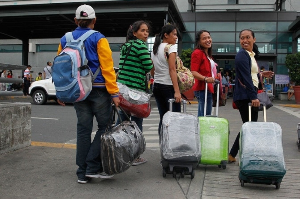 
Overseas Filipino Workers (OFW) stand by outside the Ninoy Aquino International Airport in Pasay City, Metro Manila, Philippines. Image for illustration only. — Reuters 