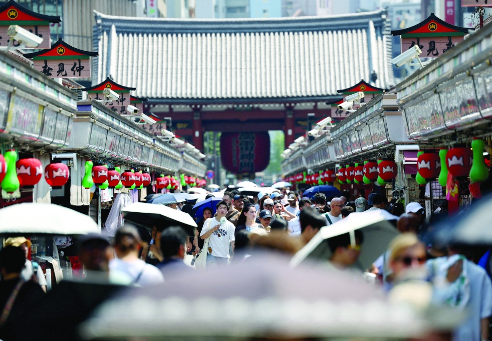 Visitors holding parasols walk along Nakamise Street at the Asakusa district, a popular sightseeing spot, as the Japanese government issued a heatstroke alert in Tokyo and other prefectures due to a heatwave, in Tokyo, Japan July 22, 2026. REUTERS/Issei Kato