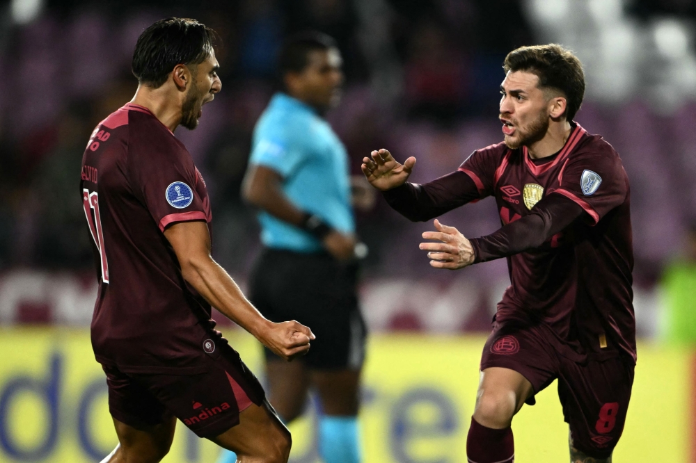 Lanus' midfielder #08 Franco Watson (R) celebrates with teammate midfielder #11 Eduardo Salvio after scoring his team's first goal 