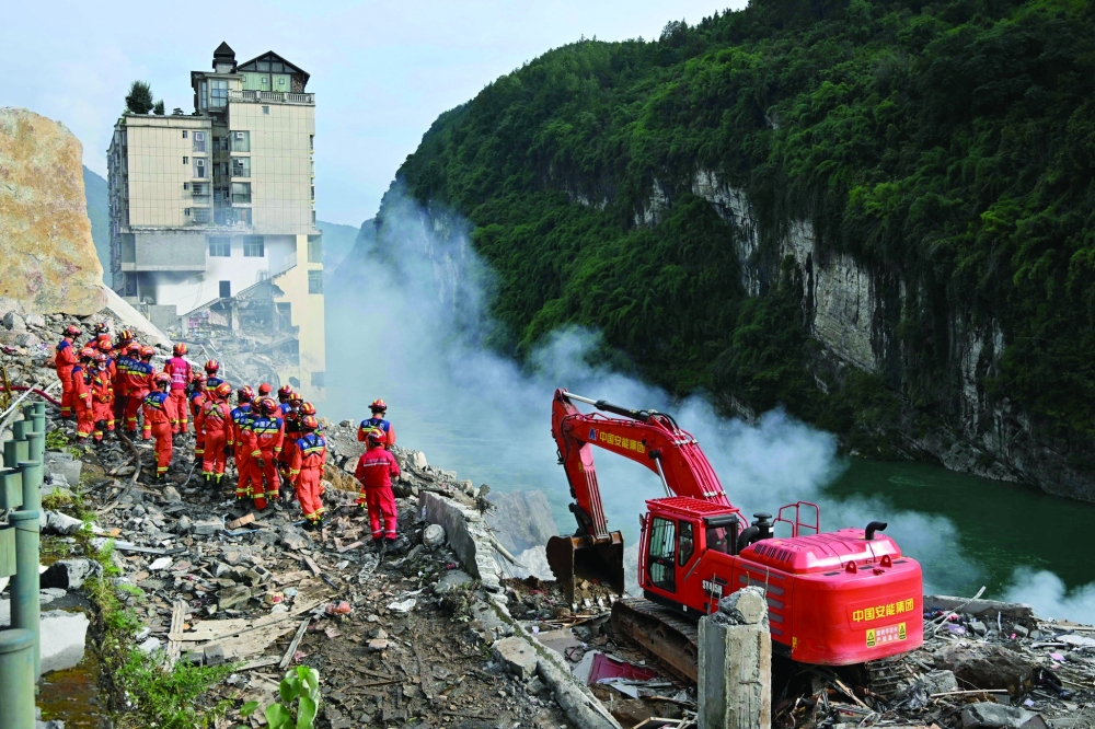 Rescue workers search for survivors at the site of a landslide in Pengshui County in Chongqing, China. — AFP