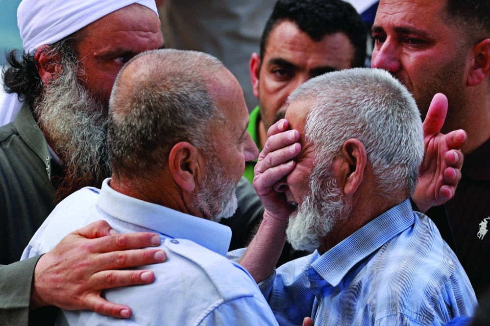 Family members of one of the four Palestinians who died in the clashes weep outside a hospital in Nablus, in the occupied West Bank. - AFP