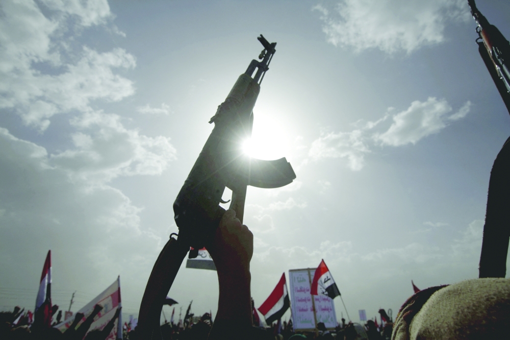 An Ansar Allah fighter raises a weapon in Yemen's capital, Sanaa. — Reuters