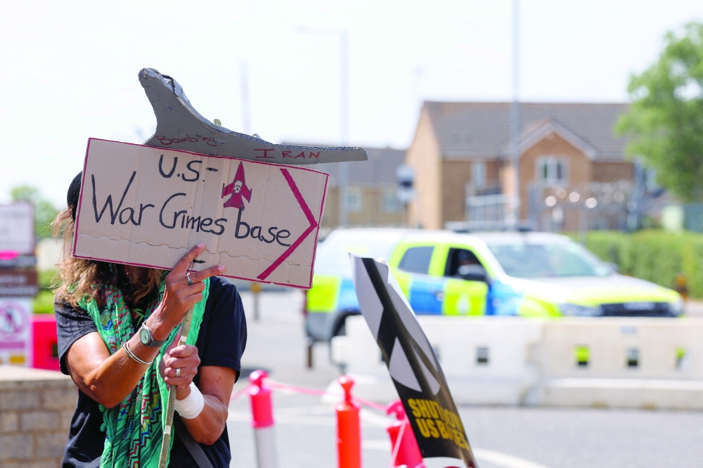 A protester stands near a police vehicle while attending an anti-war demonstration outside the main gate of RAF Fairford airbase in Fairford, Gloucestershire, Britain, on Saturday. — Reuters