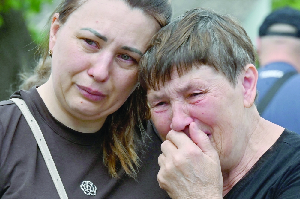 Residents mourn following an air attack in Kharkiv. — AFP