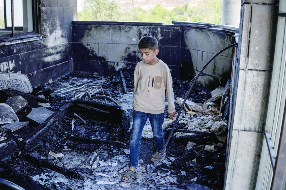 A young Palestinian boy is seen at a mosque allegedly burned by Israeli settlers in the village of Qusra, south of Nablus. — AFP