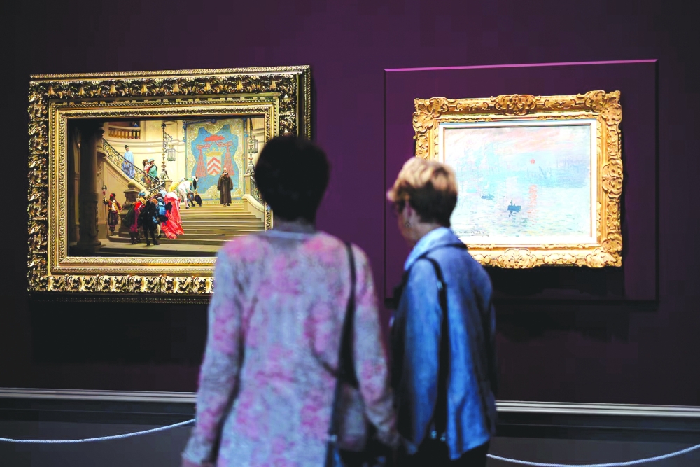 Museum visitors admire displayed impressionist works