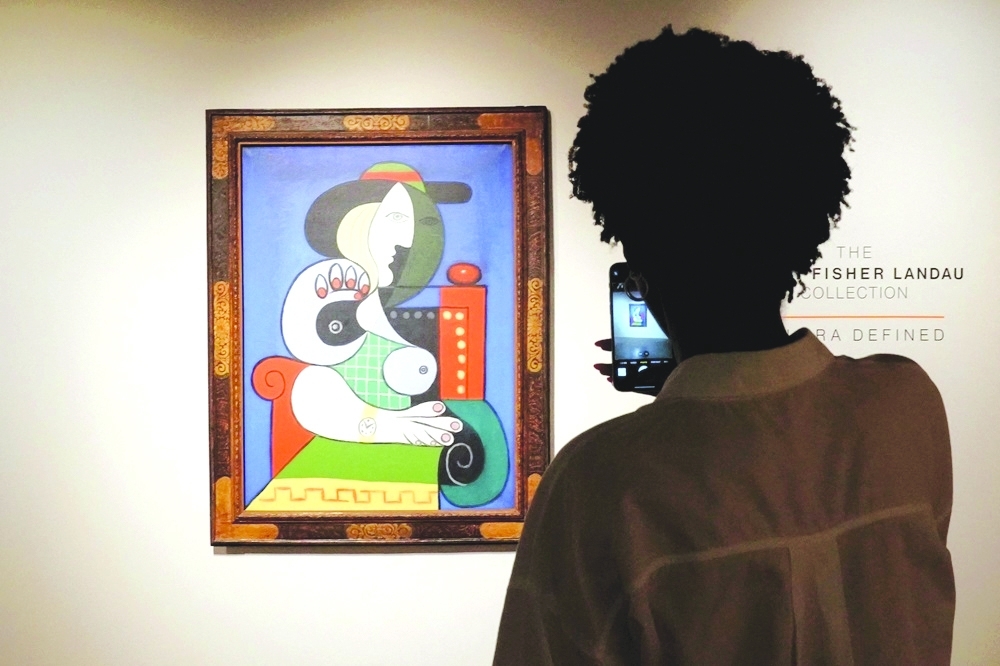 Museum visitor admires Picasso's painting while taking a picture. 