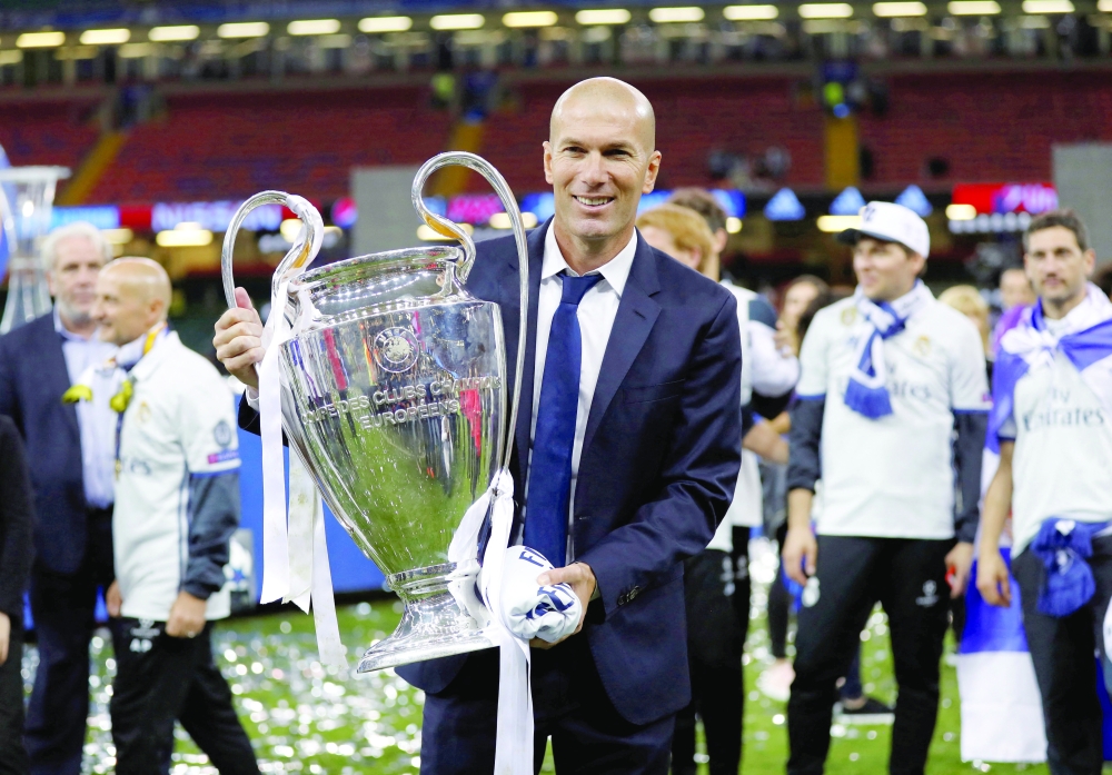Coach Zinedine Zidane celebrates with the trophy after winning the UEFA Champions League Final