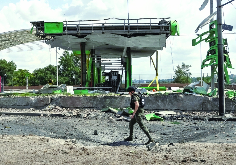 A prosecutor's office employee walks at the site of a petrol station hit by a Russian air strike in Zaporizhzhia 