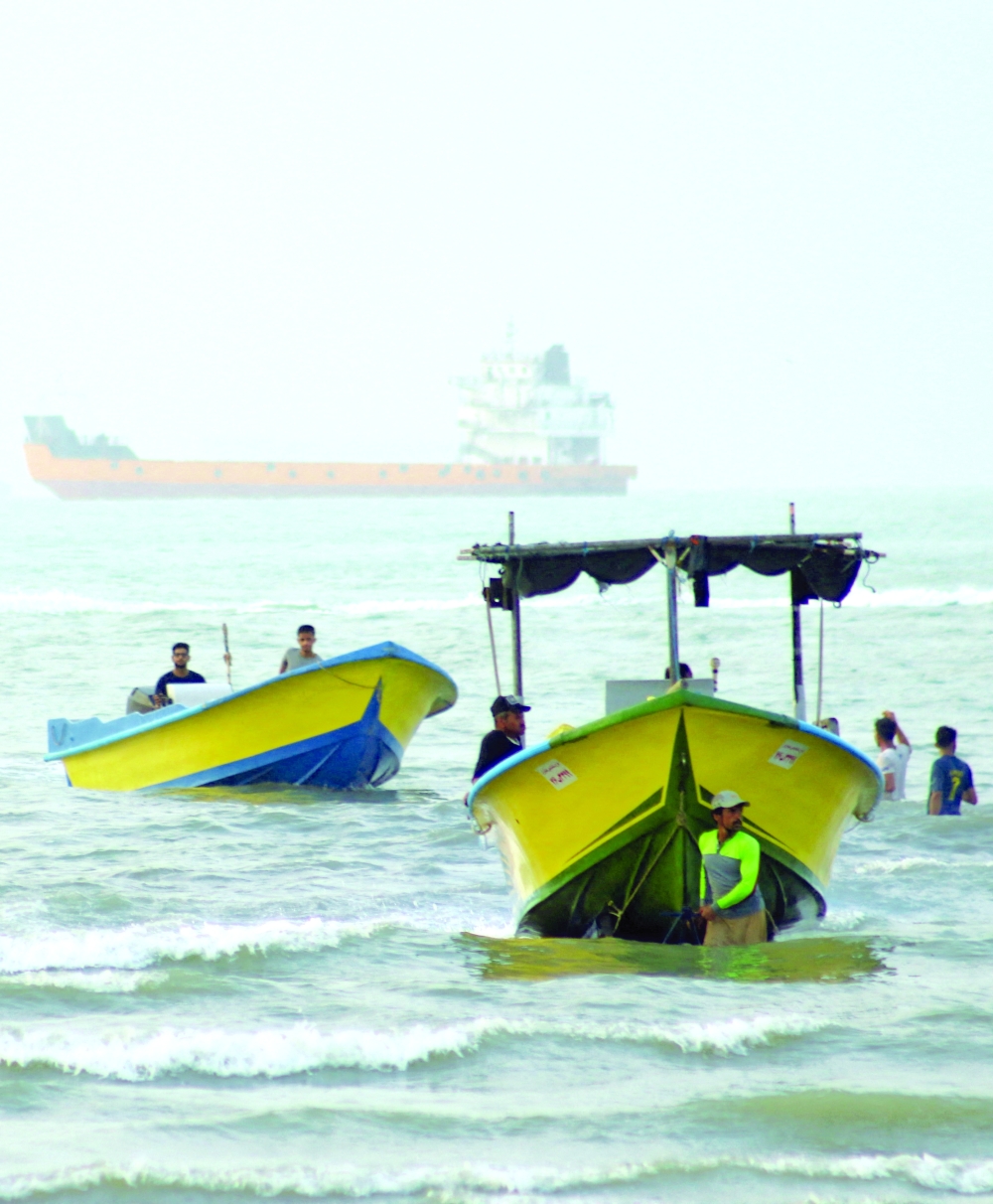 A vessel is seen in the Strait of Hormuz as people use boats near the beach of Bandar Abbas 