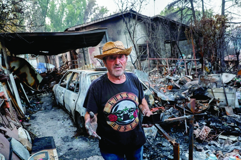 A man is pictured at his burnt-out home following a devastating wildfire in Pelayos de la Presa