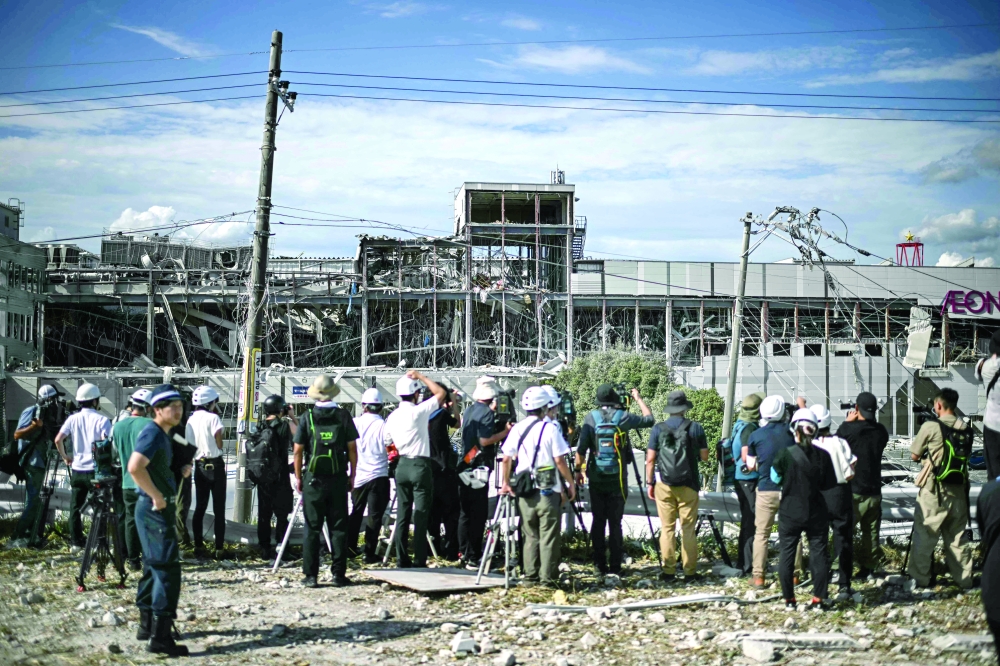Journalists gather outside the damaged Aeon Mall Kumamoto in Kashima, Kumamoto Prefecture