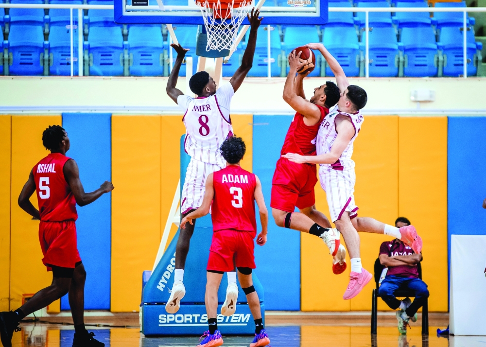 Oman player attacks Qatar basket.