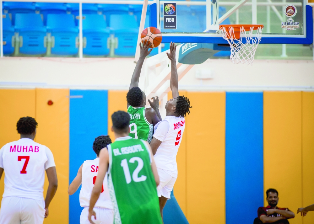 Oman players defend against a Saudi Arabia attack in the closing round of the Gulf qualifiers.