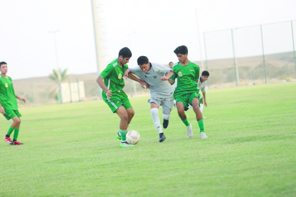 Young Omani footballers in action.
