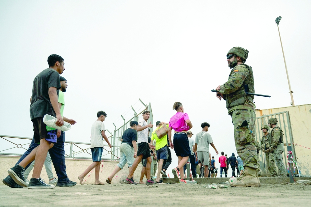Migrants cross back to Morocco after they crossed the border to enter Spain's north Africa's Ceuta enclave. - AFP
