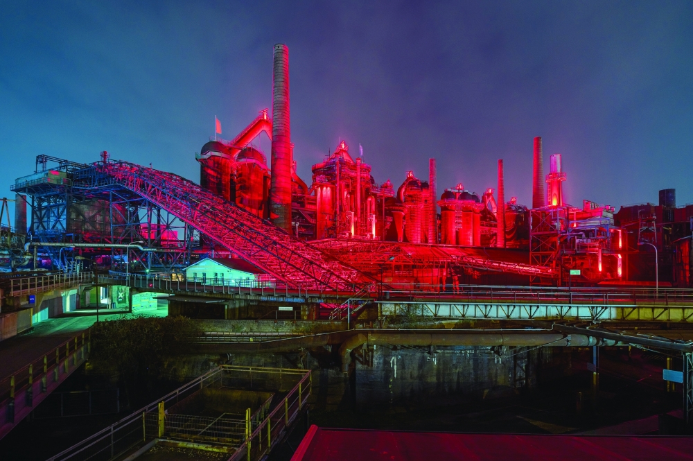 The iconic blast furnace group at Völklinger Ironworks illuminated in red. 