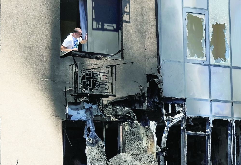 A resident looks out of a window of an apartment building damaged by a Russian drone strike in Odesa, Ukraine. — Reuters 