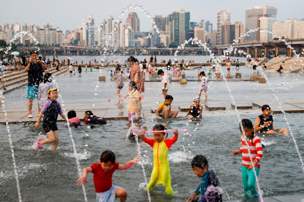 Children play in a fountain to cool off at a public water plaza along the Han River during a heatwave in Seoul, South Korea, July 31, 2026. REUTERS/Kim Soo-hyeon     TPX IMAGES OF THE DAY     