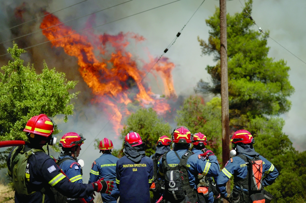 Firefighters battle wildfire near the village Agia Paraskevi, Greece. — Reuters 