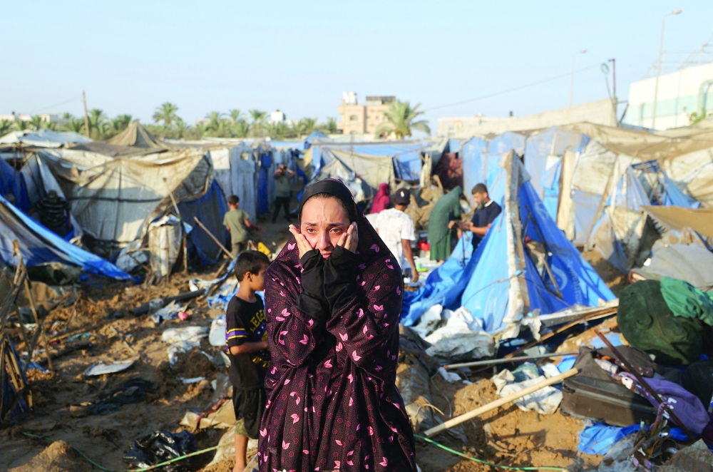 A displaced Palestinian woman reacts as she looks at the destruction of tent shelters following an Israeli air strike in Deir Al Balah, central Gaza Strip. — AFP