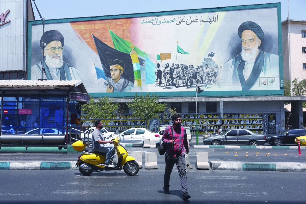 People walk past a mural depicting the late leader of the Islamic Revolution, Ayatollah Ruhollah Khomeini, and Iran's late Supreme Leader Ayatollah Ali Khamenei, on a street in Tehran. — Reuters