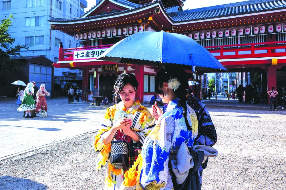 Cosplayers (L) gather at the Osu Kannon temple before the Osu Cosplay Parade. — AFP