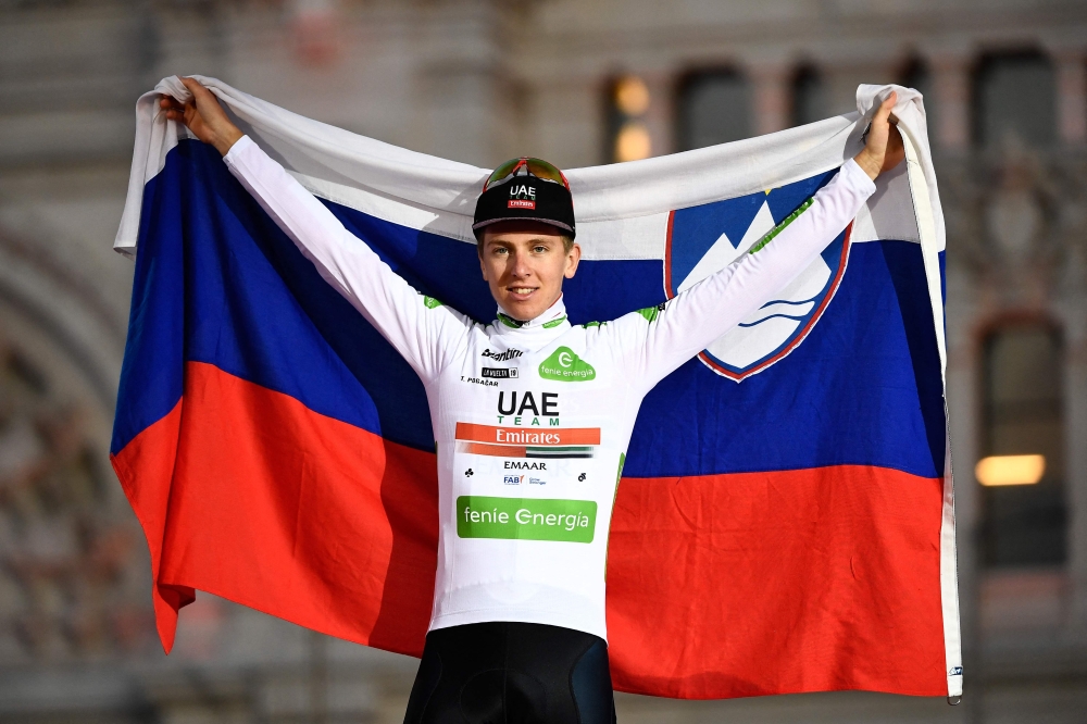 Slovenia's Tadej Pogacar celebrates his third place on the podium with the Slovenian flag. — AFP
