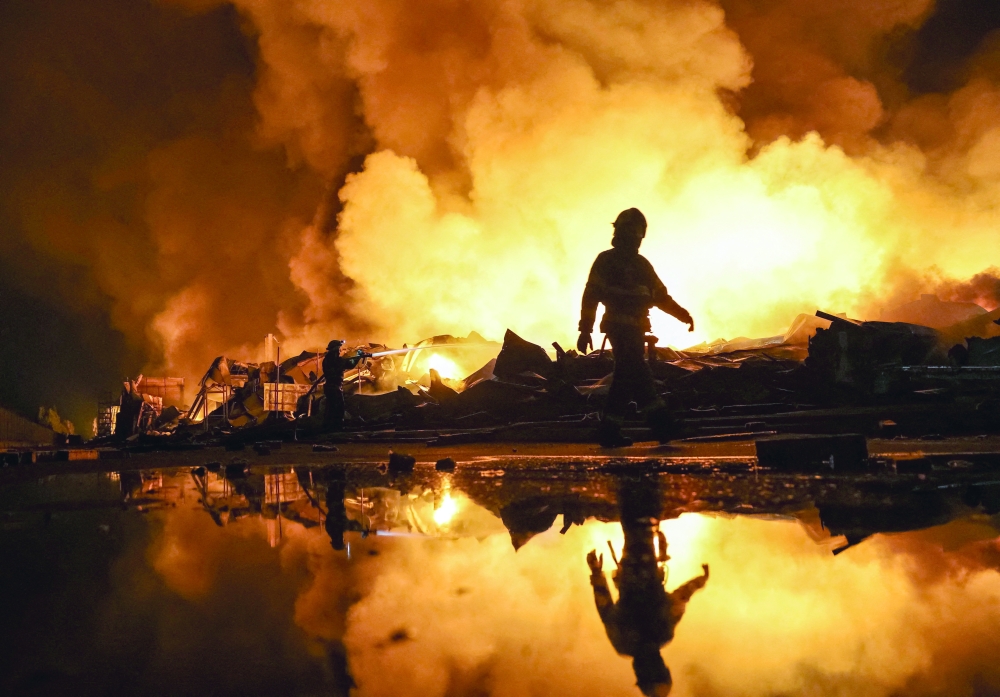 Firefighters work at a site of a Russian missile strike in Kyiv region on Wednesday. — Reuters