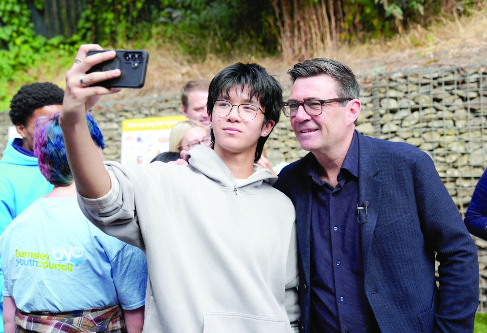 Britain's Prime Minister Andy Burnham has a selfie taken during a visit to a family centre in Sheffield, South Yorkshire. - AFP