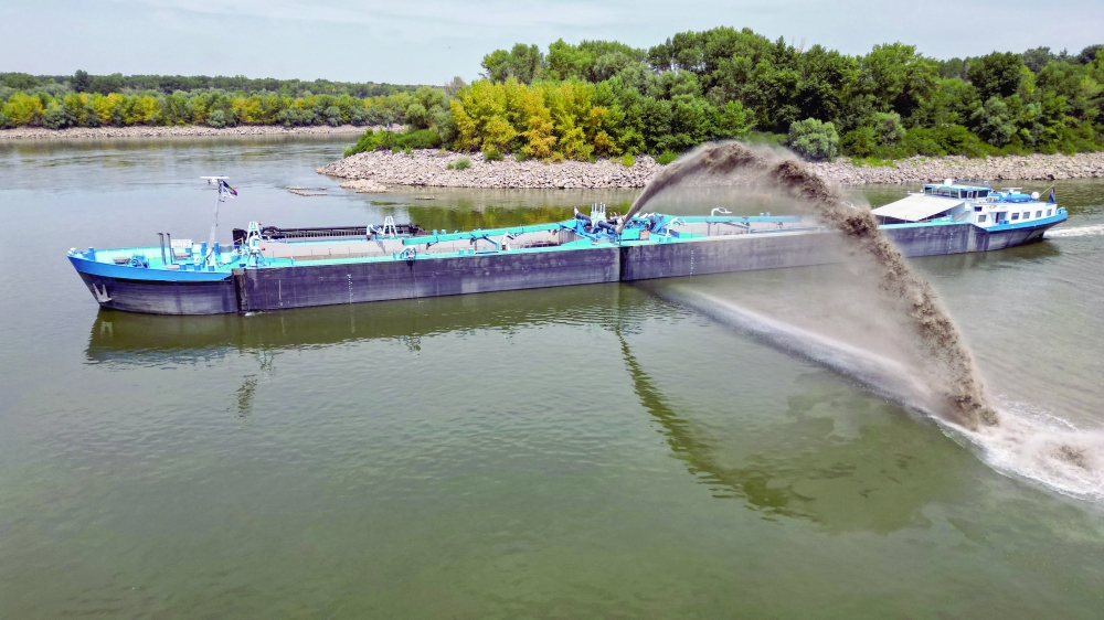An aerial view shows a dredge ship at the splitting point of Danube with Bala branch and Old Danube, the place where a controlled underwater explosion took place on the riverbed of the Danube River in Izvoarele village. 
— AFP
