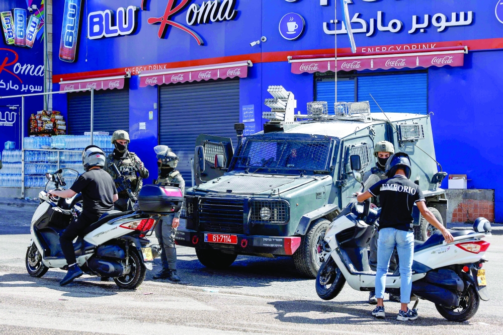 Israeli security forces stop Palestinian motorists for inspection at a checkpoint during an Israeli military raid in the Qalandia refugee camp in the Israeli-occupied West Bank. — AFP