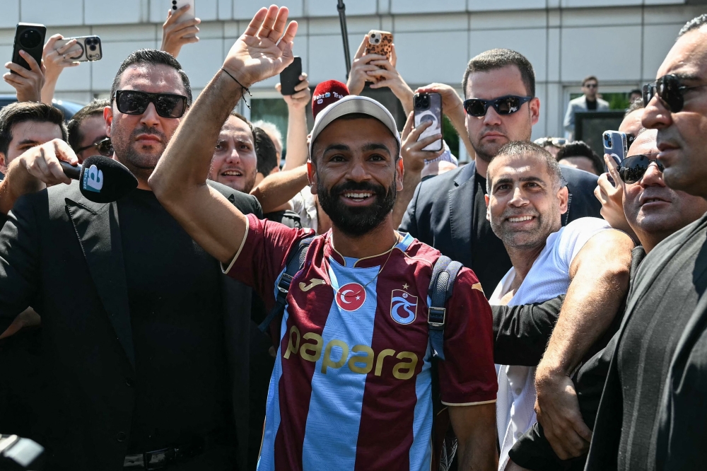Egyptian forward Mohamed Salah gestures as he arrives at Istanbul Ataturk Airport to complete his transfer to Turkish football club Trabzonspor in Istanbul on August 5, 2026. (Photo by Ozan KOSE / AFP)
