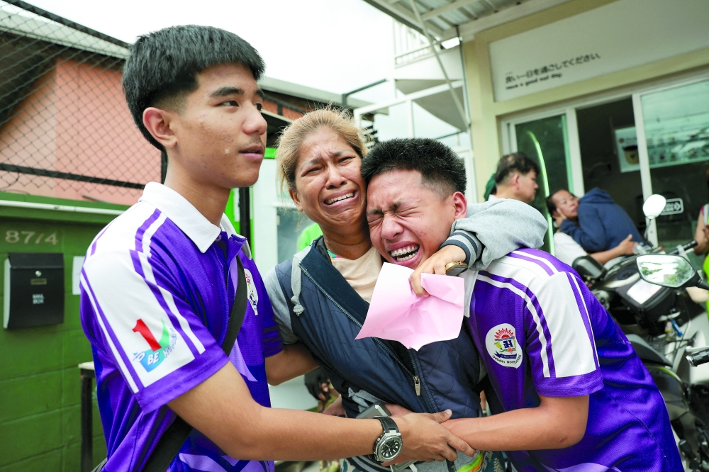 Students react with a relative after being evacuated from Debsirin Nonthaburi School, the site of a shooting incident, in Bang Kruai district in Nonthaburi province on the outskirts of Bangkok. — Reuters