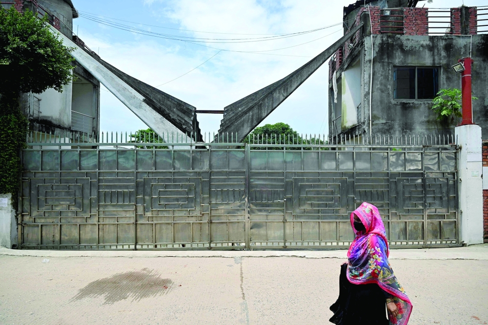 A woman walks past the closed Lithe Group garments factory at Baniachala in Bangladesh's Gazipur district. - AFP