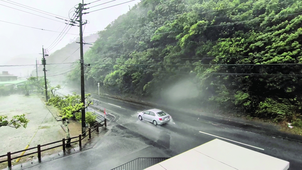 A car makes its way through strong winds and rain as Typhoon Dolphin approaches, in Nazeasahicho, Japan. — Reuters 