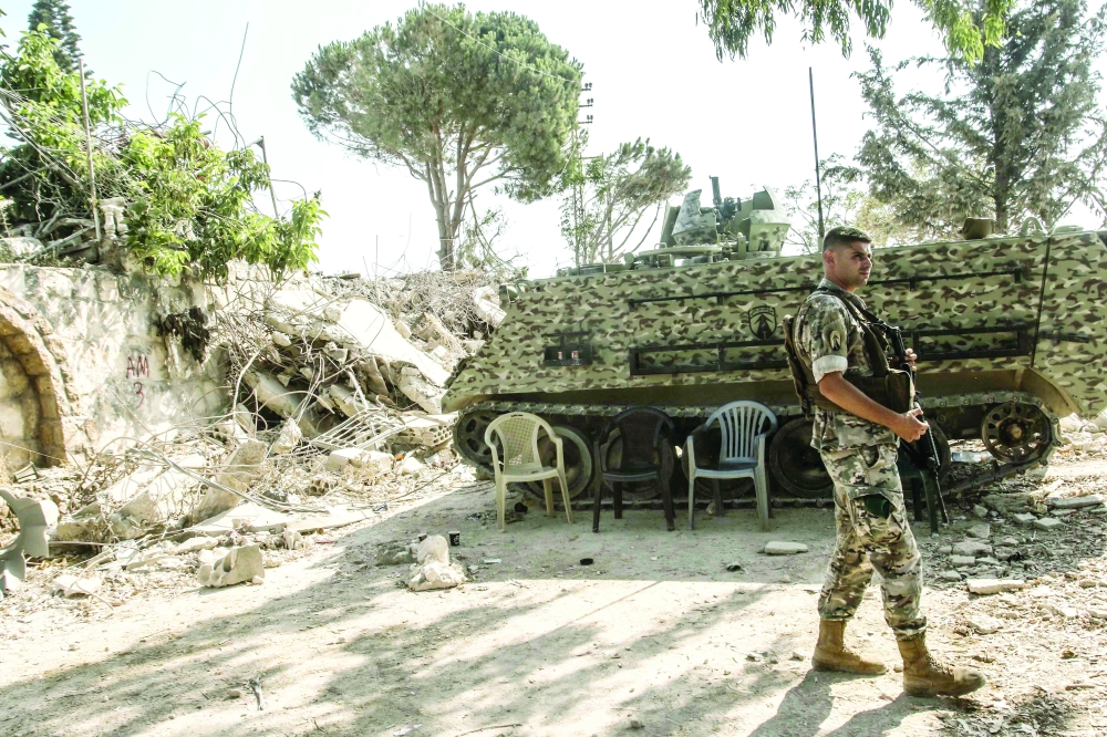A Lebanese army soldier stands on guard by his armoured vehicle in the southern Lebanese village of Zawtar al-Gharbiyah. — AFP 