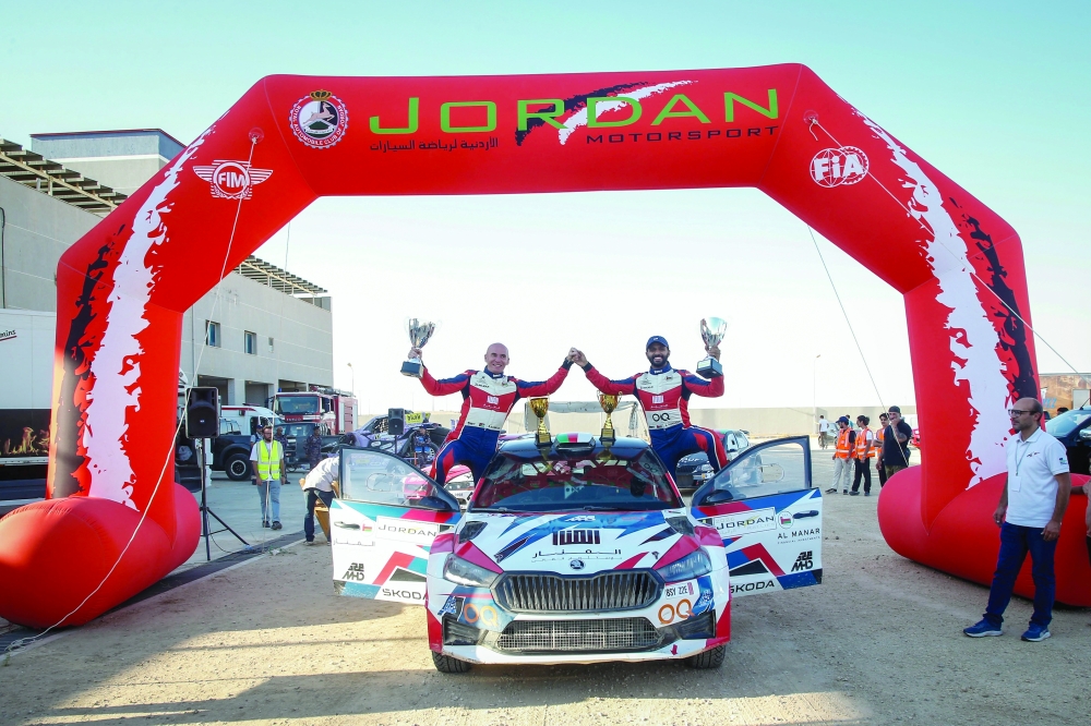 Oman's Abdullah al Rawahi and Jordanian co-driver Atta al Hamood celebrate with their trophies.