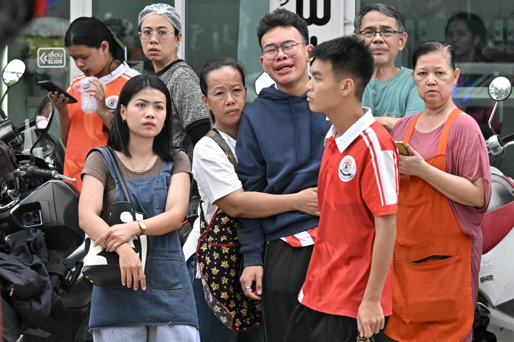 People gather outside a school following a shooting in Bang Kruai district, Nonthaburi province, north of Thailand's capital, Bangkok, on August 7