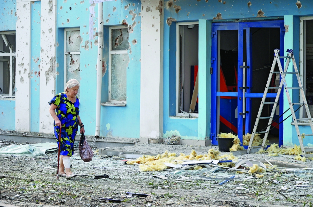 A woman walks past a bank building damaged during a Ukrainian overnight drone attack in Belgorod, Russia. — Reuters