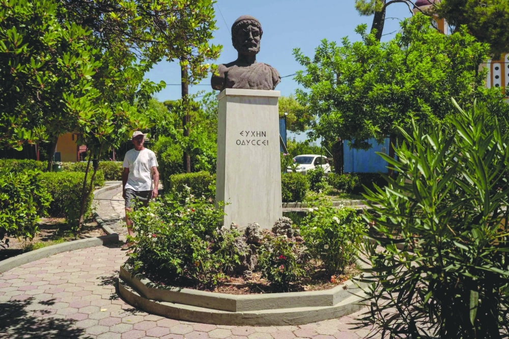 A child plays football next to a marble bust Homer on Ithaca — AFP