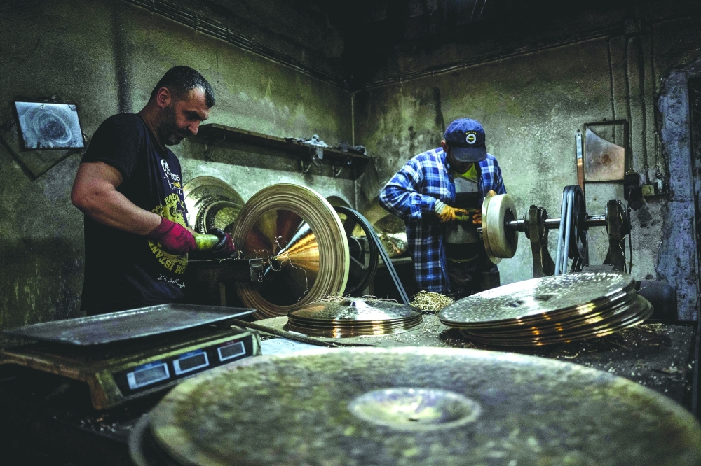 Employees work on a cymbal at a workshop in Istanbul — AFP
