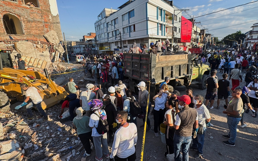 Residents and emergency personnel dig through the debris of a collapsed building following an earthquake, in Cali, Colombia August 10, 2026. 