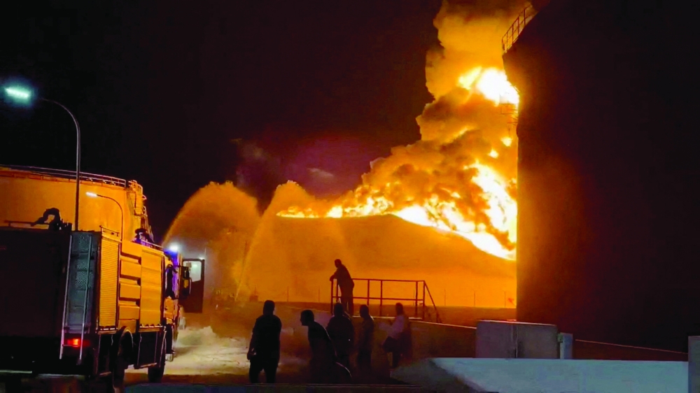 A fire in a storage tank burns as firefighters work to control the blaze, at an oil refinery in Zawiya, Libya. — Reuters 