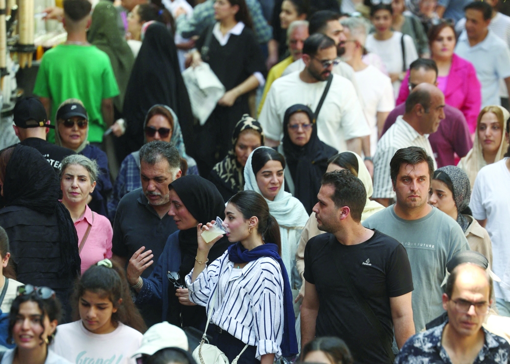 People walk in the Grand Bazaar in Tehran, Iran, on Tuesday. — Reuters