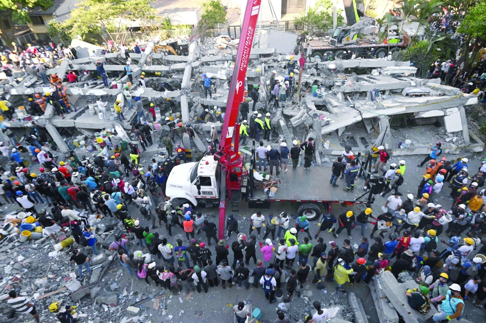 Rescuers and volunteers search for survivors amid the rubble of a collapsed building after an earthquake in Cali, Colombia. — AFP