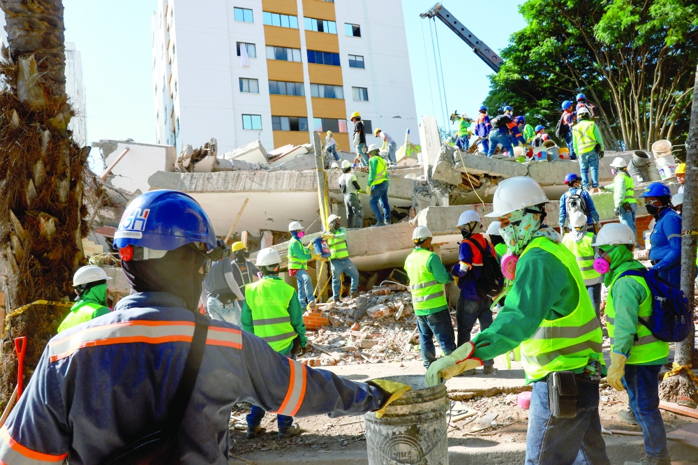 Rescuers work at the site of a collapsed building in the aftermath of an earthquake, in Cali, Colombia. - Reuters
