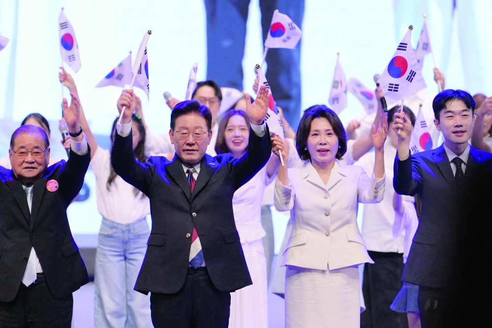 South Korean President Lee Jae Myung (centre L) and his wife Kim Hea Kyung wave the national flags during a ceremony to celebrate the 81st anniversary of the Korean Liberation Day in Seoul. — AFP
