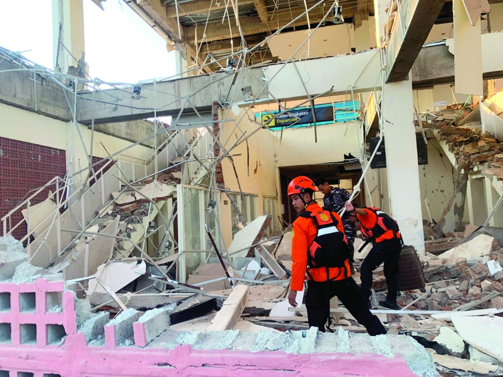 Rescuers inspect a heavily damaged building after an earthquake in Sikka, Maumere, Indonesia. — Reuters