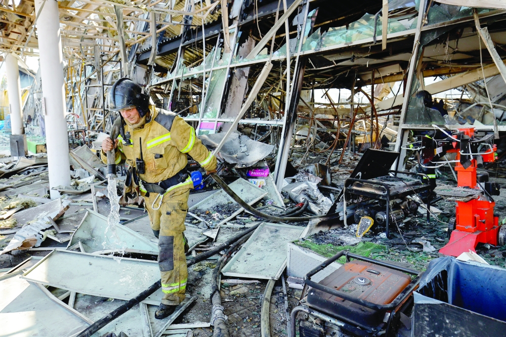A firefighter walks amid debris at a burnt-out hypermarket following an overnight attack, in the Donetsk region. — Reuters 